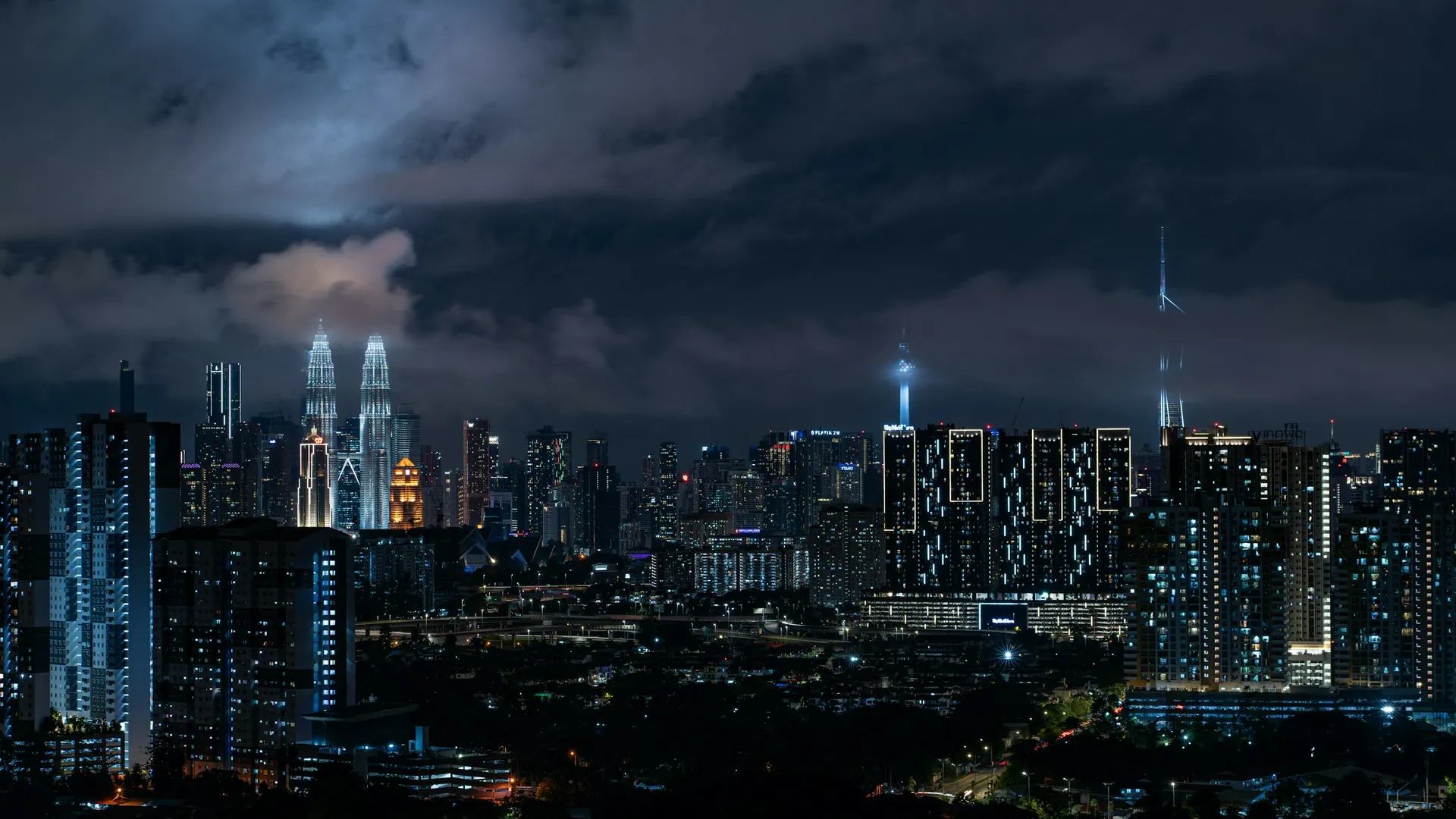 Contact Rolex Malaysian: Kuala Lumpur skyline at night with the Petronas Twin Towers