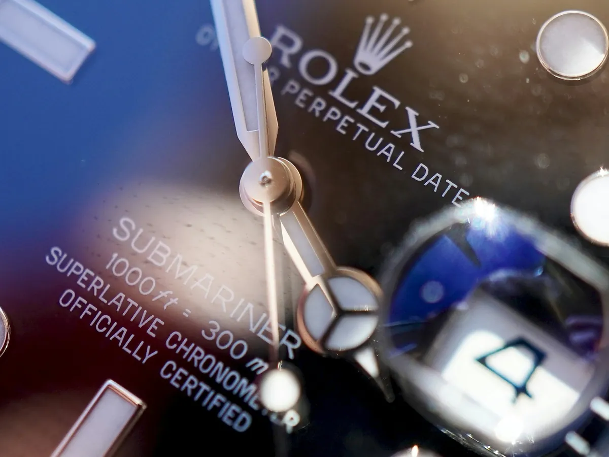 Genuine Rolex cyclops lens magnifying the date on a Submariner, a key check in telling real vs fake